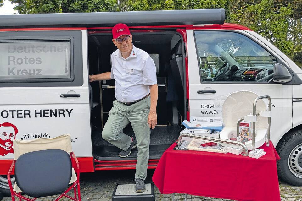 „Macht doch keine halben Sachen!“: Marcus Dannfeld, Wohnberater beim Kreisverband Mannheim des Deutschen Roten Kreuzes (DRK), vor dem Kleinbus „Roter Henry“ auf dem Rathausvorplatz in Schriesheim. Foto: Bub